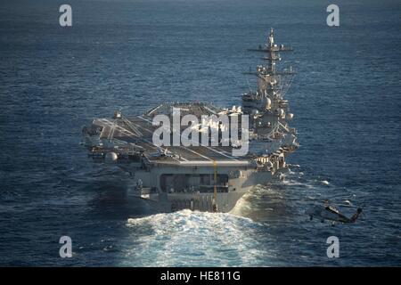 Un Sikorsky MH-60S hélicoptère Seahawk vole derrière la marine américaine de classe Nimitz porte-avions USS George H. W. Bush en transit le 2 décembre 2016 dans l'océan Atlantique. Banque D'Images