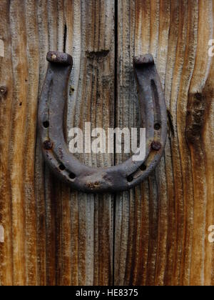 Horseshoe accroché sur la porte de bois Banque D'Images