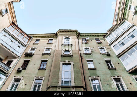 Vue de bas en haut le ciel, de grandes maisons anciennes, de puits, d'un balcon. Banque D'Images