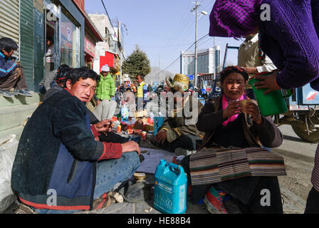 Shigatse (Xigazê) : Les Tibétains célèbrent le festival du Nouvel An tibétain sur le sentier ; Chang (bière d'orge fermenté) soit remplie, Tibet, Chine Banque D'Images