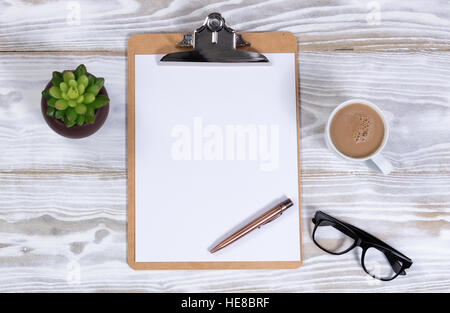 Presse-papier et stylo avec lunettes de lecture, et des plantes de café crémeux blanc rustique sur desktop Banque D'Images