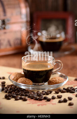 Café espresso italien dans la tasse en verre avec des biscuits amaretti autour Banque D'Images