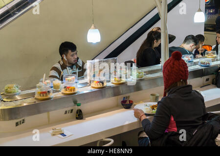 Bande de sushi dans occupé de restauration dans le Queens Center Mall dans le borough du Queens à New York sur la soi-disant Super Samedi, Décembre 17, 2016. Parce que la veille de Noël et d'Hanukah tombent tous deux le samedi c'était la dernière journée de samedi shopping avant les vacances. (© Richard B. Levine) Banque D'Images