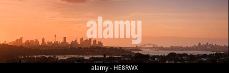 Panorama de la ville de Sydney CBD landmarks de tours gratte-ciel à arch de Harbour Bridge en Orange teinte de coucher du soleil. Banque D'Images