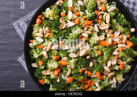 L'alimentation saine : Le brocoli avec les arachides et les carottes sur une plaque noire horizontale vue du dessus. Banque D'Images