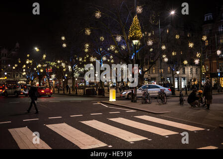 Vue de nuit sur Sloane Square avec lumière de Noël décorations et les personnes qui traversent la route à Chelsea, Londres, Royaume-Uni. Banque D'Images