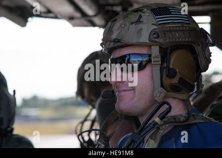 Un pararescueman affecté à la 210e Escadron de sauvetage, Alaska Air National Guard, attend à bord d'un HH-60G Pave Hawk tout en menant des opérations de vol sur Joint Base Elmendorf-Richardson, Alaska, le 23 juillet 2015. Le 210e Escadron de sauvetage d'urgence fournit les services de secours pour les citoyens de l'Alaska en plus d'une formation pour lutter contre la guerre des missions de recherche et sauvetage. Alejandro Pena) Banque D'Images