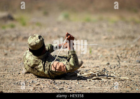 Soldat de l'ANA tire sur la corde pour exposer fil connecté à une simulation d'IED au cours de la réduction de risque d'explosion en cours au Camp Hero dans la province de Kandahar, Afghanistan, 5 avril 2012. Trente élèves durant quatre semaines d'apprentissage deux coalition et deux instructeurs afghans sur les tactiques des talibans, comment identifier les points vulnérables, afin de confirmer la présence d'un dispositif explosif, et comment faire pour supprimer la menace d'EEI. Partenaires de coalition de Paladin Task Force (Sud) pense que les instructeurs afghans uniquement le personnel sera le cours d'ici le milieu ou la fin de l'été 2003. Banque D'Images