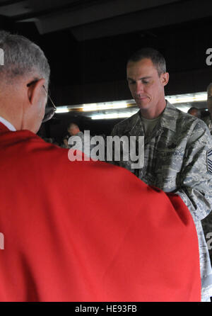 JOINT BASE BALAD, de l'Iraq - capitaine principal Sgt. Joseph Davis, 332e Escadre expéditionnaire de la surintendant des Affaires publiques, reçoit la Sainte Communion à Sustainer Theatre ici le 10 avril de l'Archevêque Mgr Timothy Broglio, pour les Services militaires aux Etats-Unis. L'archevêque a mené bon vendredi ici. Originaire de Warrensburg, N.Y., le Sergent Davis est déployée ici à partir de la Base aérienne de Ramstein, en Allemagne. Tiffany Trojca Senior Airman) Banque D'Images