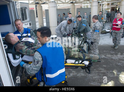 Aviateurs de 673d Medical Group transférer un tremblement de terre simulé la victime du lieu d'une ambulance pour le triage à Joint Base Elmendorf-Richardson, Alaska, le 27 mars 2014, au cours de la Mission de JBER 14-3 Exercice d'assurance. MAE 14-3 est un exercice visant à tester l'JBER la capacité de survie de base, d'exploiter et de coordonner lors d'une catastrophe naturelle majeure. Justin Connaher) Banque D'Images