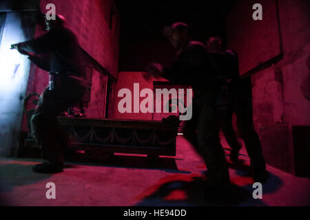 Les fonctionnaires de police affectés à l'Atlantic City Special Weapons and Tactics (SWAT) claire de l'équipe d'une zone urbaine en cas de faible luminosité l'entraînement tactique au New Jersey la formation conjointe de la Garde nationale et de la Formation Centre de développement (JT2DC), Joint Base McGuire-Dix-Lakehurst, New Jersey), 14 octobre, 2016. Le JT2DC est utilisé par les militaires, les autorités civiles, et ses alliés étrangers pour la formation et dispose de l'environnement de combat virtuel interactif (Vice), les opérations militaires en territoire urbain (MOUT) Immersion/nuit Voies de lutte contre l'incendie, appel à Trainer (CFFT) et d'Immersion Lane, des compétences en motivation Traine Banque D'Images
