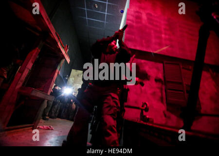 Les fonctionnaires de police affectés à l'Atlantic City Special Weapons and Tactics (SWAT) claire de l'équipe d'une zone urbaine en cas de faible luminosité l'entraînement tactique au New Jersey la formation conjointe de la Garde nationale et de la Formation Centre de développement (JT2DC), Joint Base McGuire-Dix-Lakehurst, New Jersey), 14 octobre, 2016. Le JT2DC est utilisé par les militaires, les autorités civiles, et ses alliés étrangers pour la formation et dispose de l'environnement de combat virtuel interactif (Vice), les opérations militaires en territoire urbain (MOUT) Immersion/nuit Voies de lutte contre l'incendie, appel à Trainer (CFFT) et d'Immersion Lane, des compétences en motivation Traine Banque D'Images