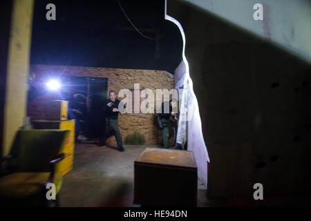 Les fonctionnaires de police affectés à l'Atlantic City Special Weapons and Tactics (SWAT) claire de l'équipe d'une zone urbaine en cas de faible luminosité l'entraînement tactique au New Jersey la formation conjointe de la Garde nationale et de la Formation Centre de développement (JT2DC), Joint Base McGuire-Dix-Lakehurst, New Jersey), 14 octobre, 2016. Le JT2DC est utilisé par les militaires, les autorités civiles, et ses alliés étrangers pour la formation et dispose de l'environnement de combat virtuel interactif (Vice), les opérations militaires en territoire urbain (MOUT) Immersion/nuit Voies de lutte contre l'incendie, appel à Trainer (CFFT) et d'Immersion Lane, des compétences en motivation Traine Banque D'Images