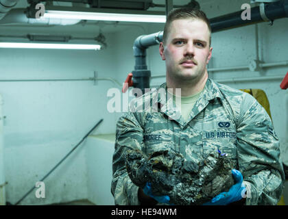 U.S. Air Force Troy Navigant de première classe, un Moncrief 354e Escadron de génie civil apprenti des eaux usées, affiche suspension retirées des eaux usées après avoir supprimé de un piège sous terre à l'Eielson Air Force Base, Alaska, usine de traitement des eaux usées, 14 juillet 2016. Tout ce qui ne peut pas être traitée par l'aération, des bactéries ou des produits chimiques est retiré avant d'entrer dans les bassins de décantation et d'étangs. Le s.. Shawn Nickel) Banque D'Images