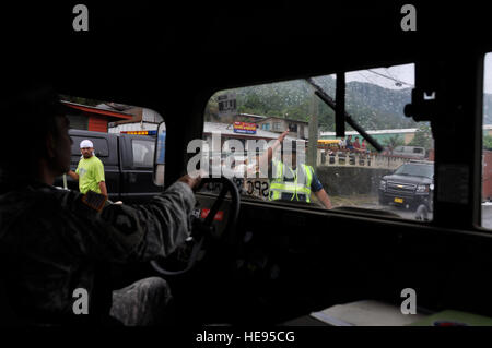 PAGO Pago Samoa Américaines - un agent de la circulation à travers la foule dirige le trafic et endommagé le long de la route du port de Pago Pago, Samoa américaines le 1er octobre 2009 après un tsunami a causé une grande quantité de dommages structuraux à l'île et c'est le 29 septembre, 2009 villages. (U.S. Air Force photo/Tech Sgt. Cohen A. Young) Banque D'Images