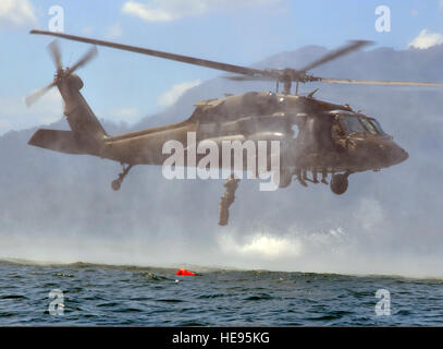 Un service américain membre avec Joint Task Force-Bravo saute d'une armée américaine d'hélicoptères UH-60 Black Hawk au cours de formation helocast au lac Yojoa, Honduras, le 25 février 2014. Plusieurs membres du groupe de travail a passé la journée en formation helocasting, la spéléologie et l'échelle des opérations de levage sur pilotis. Le groupe de travail mixte, effectue des opérations combinées et interagences et prend en charge les opérations d'urgence tout au long de la zone géographique afin de renforcer theaterwide sécurité opérationnelle et renforcer la coopération régionale. Le capitaine Zach Anderson Banque D'Images