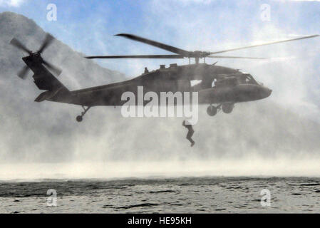 Un service américain membre avec Joint Task Force-Bravo saute d'une armée américaine d'hélicoptères UH-60 Black Hawk au cours de formation helocast au lac Yojoa, Honduras, le 25 février 2014. Plusieurs membres du groupe de travail a passé la journée en formation helocasting, la spéléologie et l'échelle des opérations de levage sur pilotis. Le groupe de travail mixte, effectue des opérations combinées et interagences et prend en charge les opérations d'urgence tout au long de la zone géographique afin de renforcer theaterwide sécurité opérationnelle et renforcer la coopération régionale. Le capitaine Zach Anderson Banque D'Images