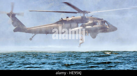 Un service américain membre avec Joint Task Force-Bravo saute d'une armée américaine d'hélicoptères UH-60 Black Hawk au cours de formation helocast au lac Yojoa, Honduras, le 25 février 2014. Plusieurs membres du groupe de travail a passé la journée en formation helocasting, la spéléologie et l'échelle des opérations de levage sur pilotis. Le groupe de travail mixte, effectue des opérations combinées et interagences et prend en charge les opérations d'urgence tout au long de la zone géographique afin de renforcer theaterwide sécurité opérationnelle et renforcer la coopération régionale. Le capitaine Zach Anderson Banque D'Images