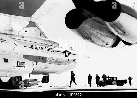 Les membres du Commandement aérien stratégique un B-52 de l'équipe de combat pour leur course toujours prêt-et-B-52 bombardier lourd d'attente. Cinquante pour cent de la force de bombardement et des camions-citernes est continuellement en alerte au sol, prêt à être en route pour l'objectif dans le délai d'alerte fournis par le système de détection lointaine des missiles balistiques. L'un des deux bombardiers chien de missiles est indiqué dans l'avant-plan. (U.S. ) Banque D'Images