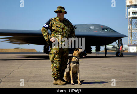 Le caporal de l'armée australienne. Tony Baker et veillent sur l'essieu d'un bombardier furtif B-2 Spirit le 27 juillet au Royal Australian Air Force Base Darwin au cours de l'effort de l'Éclair vert. Le test d'exercice des fonctions des États-Unis et fournit la connaissance pratique de la région du Pacifique pour la présence de bombardiers tout en servant à améliorer les relations avec les Australiens. Le caporal Baker est un K-9 chargeur avec la Royal Australian Defence Force. Tech. Le Sgt. Shane A. Cuomo) Banque D'Images