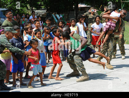 Vallée-de-Corbeau, Philippines - US Marines et marins avec un 3e Bataillon d'approvisionnement, lutter contre le régiment logistique 35, 3e Groupe Logistique Maritime, III Marine Expeditionary Force, jouer avec des élèves d'Maruglo dans l'école élémentaire de la Vallée-de-Corbeau, Philippines, le 12 avril pendant les événements de relations communautaires à Balikatan 2013, chaque année un exercice bilatéral États-Unis-Philippine. L'aide humanitaire et les activités de formation permettent à la Philippine et les forces américaines de construire des relations durables, s'entraînent ensemble et fournir une assistance dans les communautés où le besoin est le plus grand. Tech. Le Sgt. Jerome S. Taybor Banque D'Images