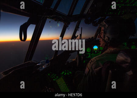 Un U.S. Air Force C-130 Hercules pilot numérise plus de centre de l'Iraq que le soleil se lèvera et que son équipage retourne à la base après avoir effectué un test de réapprovisionner un largage de plus, l'Iraq, de Bayji, 10 octobre 2014. Le C-130 a chuté 14 ensembles de systèmes de livraison de conteneurs totalisant 3 800 repas prêt à manger et 1 400 litres d'eau potable. Airman Senior Matthieu Bruch)(1992) Banque D'Images