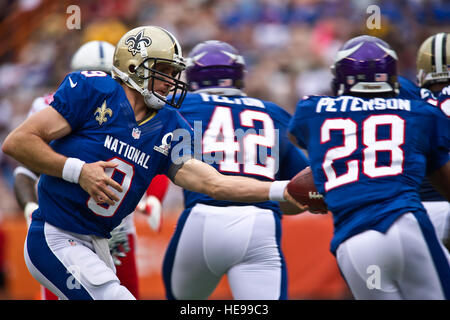 New Orleans Saints Drew Brees, quart-arrière, les mains le ballon à Minnesota Vikings en marche arrière, Adrian Peterson, au cours du premier trimestre 2013 de la Ligue nationale de football Pro Bowl, le 27 janvier., à l'Aloha Stadium d'Honolulu. Plusieurs centaines de militaires affectés à diverses bases Hawaii ont été honorés lors de la cérémonie d'ouverture des jeux et de la fête de la mi-temps. ( U.S. Air Force Tech. Le Sgt. Michael R. Holzworth Banque D'Images