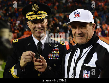 L'Armée américaine, le général Reynold N. Hoover, Assistant de mobilisation pour le directeur, Defense Intelligence Agency, présente un jeu à l'aide d'une pièce officielle avant qu'un hommage à Denver Broncos arborant de service le 27 novembre 2016, cérémonie, à Sports Authority Field at Mile High, à Denver. Le salut au programme de service est un moyen la NFL grâce aux militaires pour leur service. Spradling Gabrielle Navigant de première classe Banque D'Images