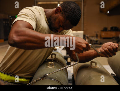 Le s.. Everett Myles utilise une poignée de vitesse pour fixer des sangles sur un laser dirigé conjointement pendant une bombe à sous-munitions d'attaque à la construction 379e escadre expéditionnaire aérienne en Asie du Sud-Ouest, 2 septembre 2013. Myles est un 379e Escadron de maintenance de la Force expéditionnaire du chef d'équipe de maintenance classiques déployés à partir de Dyess Air Force Base, Texas, et est originaire de Fort Worth, Texas. J. Jones Senior Airman Bahja) Banque D'Images