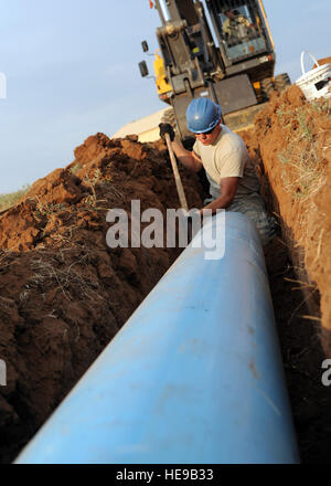 Un membre de la 1re classe Michael Wiggins, 97e Escadron de génie civil et de l'eau l'entretien des systèmes de carburant, de l'apprenti prépare un tuyau pour l'installation derrière un camion-citerne de triage de carburant, 14 août 2012. La 97e SCÉ travaille sur un projet d'irrigation de l'eau brute qui répond à un souci des coûts de la culture. L'eau d'irrigation d'eau non potable sera utilisée à l'eau le Golf Sentiers venteux, sauver la base autour de 48 000 $ sur le coût d'utilité par an et l'enregistrement de la ville d'Altus autour de 12 000 $ sur le coût de fonctionnement par an. Banque D'Images