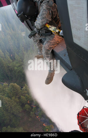 Le Sgt. Chris Boni, chef d'équipage de la Garde nationale de Californie, 1-140ème bataillon de l'Aviation (Air Assault) sur la base de formation conjointe de Los Alamitos (JFTB), les rejets de l'eau sur la tête arrosant le rim fire ci-dessous près de Yosemite National Park. La Rim Fire est maintenant la 14e plus grande forêt à l'histoire de la Californie. L'UH-60 Black Hawk les équipages se battent contre la jante de forêt à l'appui du Bureau du Service des forêts des États-Unis et Cal Fire. (U.S. Le sergent-chef de la Californie. Julie Avey Banque D'Images