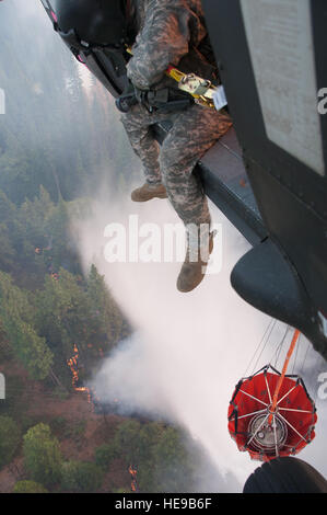 Le Sgt. Chris Boni, chef d'équipage de la Garde nationale de Californie, 1-140ème bataillon de l'Aviation (Air Assault) sur la base de formation conjointe de Los Alamitos (JFTB), les rejets de l'eau sur la tête arrosant le rim fire ci-dessous près de Yosemite National Park. La Rim Fire est maintenant la 14e plus grande forêt à l'histoire de la Californie. L'UH-60 Black Hawk les équipages se battent contre la jante de forêt à l'appui du Bureau du Service des forêts des États-Unis et Cal Fire. (U.S. Le sergent-chef de la Californie. Julie Avey) Banque D'Images