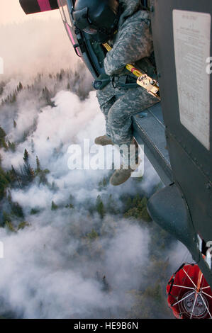 Le Sgt. Chris Boni, chef d'équipage de la Garde nationale de Californie, 1-140ème bataillon de l'Aviation (Air Assault) sur la base de formation conjointe de Los Alamitos (JFTB), les rejets de l'eau sur la tête arrosant le rim fire ci-dessous près de Yosemite National Park. La Rim Fire est maintenant la 14e plus grande forêt à l'histoire de la Californie. L'UH-60 Black Hawk les équipages se battent contre la jante de forêt à l'appui du Bureau du Service des forêts des États-Unis et Cal feu.(U.S. Le sergent-chef de la Californie. Julie Avey/ libéré) Banque D'Images