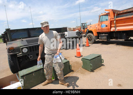 110612--UL435-163 : Dakota Dunes - PFC. Tchad Barth, infirmier de la 153e bataillon du génie de Huron, attrape quelques bouteilles d'eau pour le remplissage des sacs de sable des soldats à l'installation d'un point, dimanche, 12 juin, 2011. "Des jours chauds comme ceci, l'hydratation est très importante, le bon ratio est de cinq bouteilles d'eau pour une bouteille de Gatorade,' dit Barth. Près de 1 000 soldats et aviateurs de la Garde nationale du Dakota du Sud continuent d'effectuer diverses tâches de soutien de crue dans tout l'état. (SDNG Tech. Le Sgt. Les jeunes Quinton) Banque D'Images