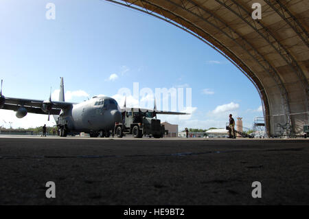 Une équipe de maintenance roues un Hercules C-130 dans un hangar du 15 décembre à la base de la Garde nationale aérienne Muñiz, Puerto Rico. Les aviateurs de la 156e e Escadron de maintenance maintenir l'Armée de l'air plus vieux du C-130. Louis A. Arana-Barradas) Banque D'Images