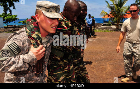 Lieutenant de l'armée américaine Justin Gilliam, Section Médicale, 2e Bataillon, 138e d'artillerie sur le terrain, les membres de l'enseigne militaire Comores divers buddy porte à Moroni, Comores, le 23 janvier 2013. Gilliam est déployée à l'appui de la Combined Joint Task Force-Horn of Africa, qui mène des opérations militaires, des activités et des exercices pour promouvoir le partenariat, la sécurité et la prospérité en Afrique de l'Est. Navigant de première classe Nicholas Byers Banque D'Images