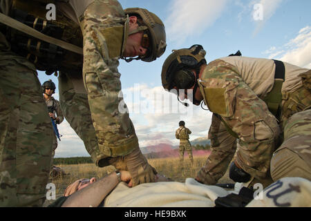 U.S. Air Force pararescuemen également connu sous le nom de PJ (para-cavalier), de l'Alaska Air National Guard Base Elmendorf-Richardson mixte, en Alaska, et de sauveteurs-parachutistes (/Anges gardiens) de la base aérienne Davis-Monthan AFB en Arizona, de dispenser des soins médicaux à une simulation d'états de service au cours de blessés au combat d'une simulation de scénario de formation le 30 juillet 2014. Les PJ sont chargés de fournir des services d'urgence et de sauvetage destinés aux militaires et civils en temps de paix et des environnements de combat, ils vont derrière les lignes ennemies avant que quelqu'un d'autre pour déterminer, sur une zone de pose/domaine de l'air et les appels à l'aide de l'appui feu. Banque D'Images