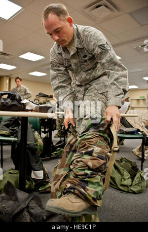 Le s.. Justin Miller, 763e Escadron de maintenance, tire de sa mission de protection de la posture pantalon lors de défense chimique, biologique, radiologique et nucléaire Défense formation en compétences de survie à Nellis Air Force Base, Nevada, 30 avril 2015. Les aviateurs sont actualisées sur les compétences indispensables qui pourraient leur sauver la vie dans l'exercice de leurs fonctions par l'apprentissage des moyens convenables pour mettre sur de l'équipement de protection en temps opportun et de manière efficace. Navigant de première classe Jake Carter) Banque D'Images