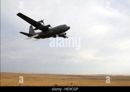 Un C-130 Hercules survole Saylor Creek Secteur de bombardement de la pulvérisation d'herbicide à la triche de contrôle dans le domaine de l'herbe, le 17 septembre 2014, à Mountain Home Air Force Base, Texas. L'herbe de triche est devenu un danger dans la région en détruisant la végétation indigène et en augmentant la probabilité d'incendies se propageant rapidement. Le 910th Airlift Wing, basé à la station de la Réserve aérienne de Youngstown, Ohio, est la maison pour le ministère de la Défense est qu'une grande surface, des capacités d'épandage aérien. Rachel Kocin Senior Airman) Banque D'Images