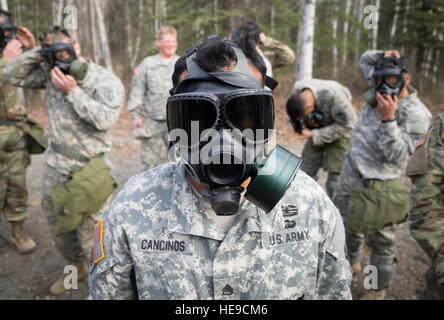 Le sergent de l'armée américaine. Henry Cancinos, attribué à Bravo Troop, 1er Escadron (Airborne), 40e Régiment de cavalerie, 4e Brigade Combat Team (Airborne), 25e Division d'infanterie de l'armée américaine, l'Alaska, procède à des armes chimiques, biologiques, radiologiques et nucléaires de la formation sur la défense Joint Base Elmendorf-Richardson, Alaska, le 13 avril 2016. La formation s'est terminée par des soldats masqués dans une chambre scellée remplie de gaz CS (gaz lacrymogène), puis de retirer leur équipement de protection pour renforcer la confiance dans leurs équipements. Justin Connaher) Banque D'Images