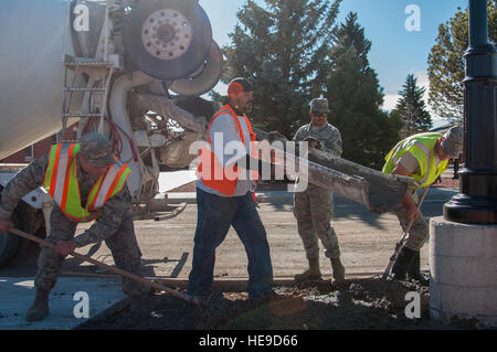 Le 90e Escadron de génie civil Travaux d'aviateurs de remplir une zone avec du béton à l'extérieur de la salle à manger sur le Chadwell F.E. Warren Air Force Base, Wyo., 10 novembre 2015. Il faut de la coordination de nombreux organismes différents de prendre un projet du berceau à la tombe. Airman Senior Jason Wiese) Banque D'Images