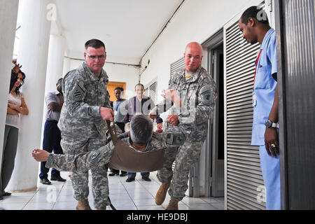 Le sergent de l'armée américaine. 1re classe Ryan Watson, à gauche, et l'Army Staff Sgt. James Gibson transporter le major Thomas Webster sur une litière pendant une démonstration de formation à l'Organisation mondiale de la Santé (OMS), Djibouti, l'Administration centrale (AC), le 22 janvier 2014. Les membres du bataillon des affaires civiles 443rd spécialité fonctionnelle de l'équipe (Fx SP) formé de représentants de divers organismes des Nations Unies sur le traitement des traumatismes durant un cours de quatre jours au siège de l'OMS. Les trois personnes de l'équipe SP Fx fait partie de la Joint Task Force-Horn of Africa. Le s.. Christopher brut) Banque D'Images