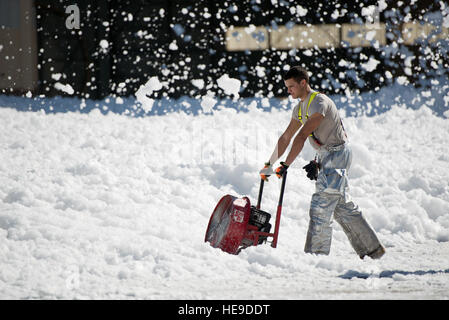 Airman Senior Allen Stoddard, 60e Escadron de génie civil, les courants d'une petite mer de mousse ignifuge qui a été involontairement dans un hangar pour avions à Travis Air Force Base, en Californie, le 24 septembre, 2013. La mousse non dangereux est semblable à du savon à vaisselle, qui a éventuellement dissous dans un liquide, qui a été aidé par des vents violents. La 60e Escadre de mobilité aérienne Les pompiers permettait de lutter contre la dispersion, à l'aide de ventilateurs puissants et couvrant les drains. Aucun peuple ou l'aéronef n'a été blessé dans l'incident. Ken Wright) Banque D'Images