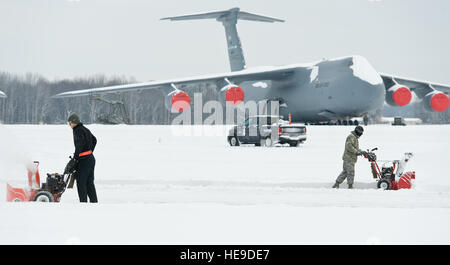 Un C-5M Super Galaxy se trouve sur la piste que les aviateurs dégager la neige le 17 février 2015, sur la base aérienne de Dover, Delaware Tempête faisant l'Octavia un total de quatre pouces de neige sur la base et dans l'ensemble de la région. Roland Balik) Banque D'Images