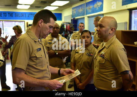 Vice-amiral. Dixon R. Smith, commandant de la Marine, de la commande des installations, demande de 1ère classe Quartier-maître Aaron Martinez s'il y a tout ce qu'il peut faire pour aider le grenier du marin, situé sur une base commune Pearl. Harbor-Hickam Les bénévoles de la Sailor's Attic fournissent des biens ménagers et autres articles pour servir ses membres et leurs familles. Au cours de sa visite de trois jours, Smith a visité plusieurs régions, s'est réuni avec les dirigeants locaux et ont entendu un exposé de l'amiral Richard L. Williams, commandant de la région, de la Marine à Hawaii. Airman Senior Christopher S. Stoltz Banque D'Images