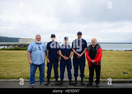 Une Garde côtière 47 pieds de la durée de vie du moteur d'équipage de bateau, pose pour une photo avec deux survivants d'un navire qui chavire dans les Makah et Bay Avril 18, 2016, après une cérémonie de remise de prix à Neah Bay Station de la Garde côtière canadienne le 24 juin 2016. L'équipage de bateau, a reçu la lettre de recommandation du Commandant barre Ruban pour sauver les pêcheurs et de les traiter pour les symptômes de l'hypothermie après les hommes ont dépensé un rapporté 70 minutes à 52 degrés de l'eau. Marin de La Garde côtière américaine Sarah Wilson. Banque D'Images