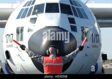 Un chef d'équipe de l'US Air Force dirige une garde côtière C-130 sur la ligne de vol à la Homestead Air Reserve Base, 20 janvier, 2010. L'aéronef a présenté aux citoyens des États-Unis d'être évacués d'Haïti après un séisme de magnitude 7,0 a causé de graves dommages en Haïti, 12 janvier 2010. Tech. Le Sgt. Andy Bellamy, U.S. Air Force Banque D'Images