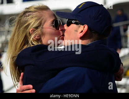 Maître de Dustin Reed, Gallatin USCGC (WHEC 721) maître de manœuvre, embrasse sa petite amie Staci Ulichnie, après son retour d'un déploiement de trois mois, le 11 décembre 2013, à Charleston, S.C. lors de la dernière patrouille, l'équipage de Gallatin ont saisi plus de 1 000 kilos de cocaïne d'une valeur de 34 millions de dollars. Airman Senior Dennis Sloan) Banque D'Images