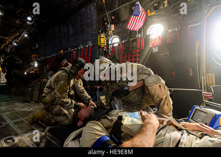 U.S. Air Force pararescuemen, 82e Escadron de sauvetage expéditionnaire (QRE), former aux côtés d'un patient simulé au cours d'un combat de l'exercice de recherche et sauvetage à bord d'un MC-130P Combat Shadow avion, 81e sur le Grand QRE, Bara Désert, Djibouti, le 20 février 2013. La récupération du personnel d'exercices d'entraînement sont régulièrement menées à l'appui de la Combined Joint Task Force-Horn of Africa. Navigant de première classe Nicholas Byers Banque D'Images