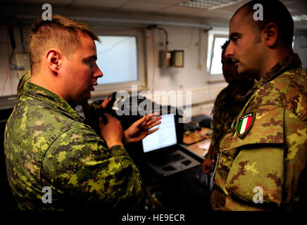 Le Cpl canadien. Daniel St. Aubin et le capitaine Italien Emanuele Tedesch discuter des problèmes de connectivité entre leurs serveurs informatiques au cours de COMBINED ENDEAVOR 2010 le 3 septembre 2010, à Grafenwoehr, Allemagne. Combined Endeavor 2010 est le premier exercice de l'interopérabilité des communications, la préparation des forces internationales de commande, de contrôle, de systèmes informatiques et de communication pour les opérations multinationales. (U.S. Air Force Photo/Navigant de première classe Samuel W. Goodman)(1992) Banque D'Images